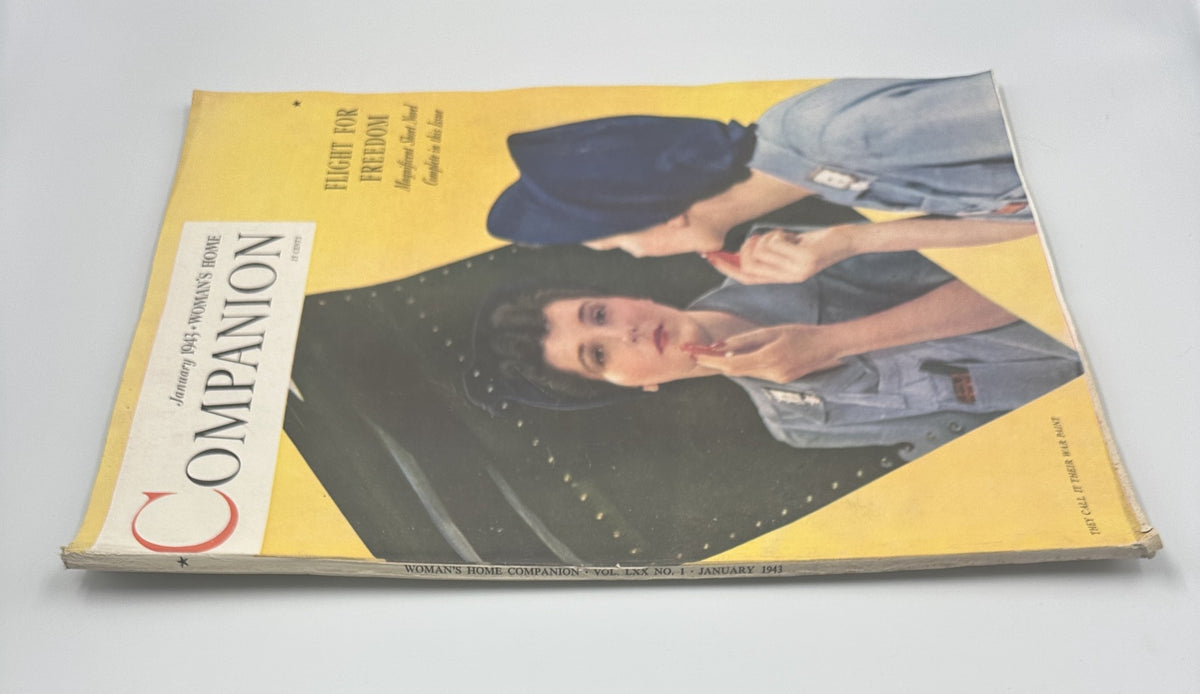 Side view of Woman’s Home Companion Magazine, January 1943, displaying the title 'Flight for Freedom'. The magazine cover features a woman in a blue outfit, preparing to apply lipstick, with hints of vintage aesthetics.