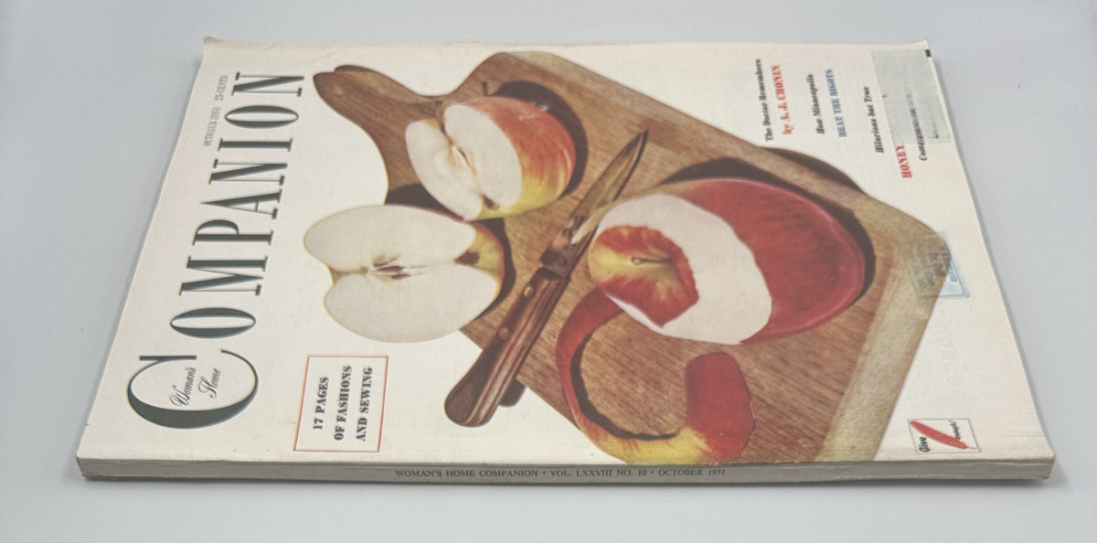 Cover of Woman’s Home Companion Magazine October 1951 featuring sliced apples on a wooden board with a knife, highlighting the issue's focus on home and cooking.