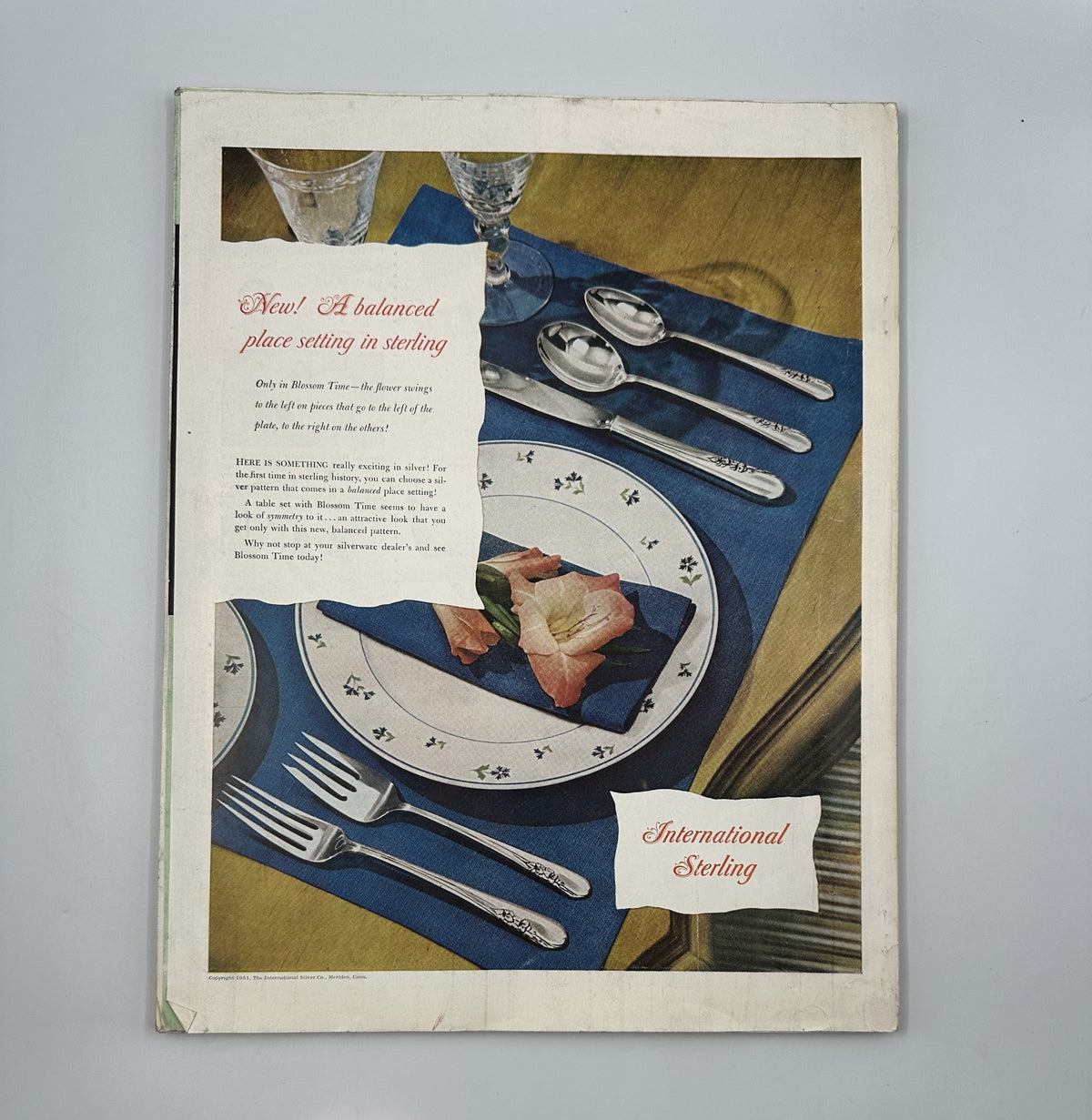 Back cover of the Woman’s Home Companion Magazine June 1951 featuring a stylish place setting advertisement for 'International Sterling'.