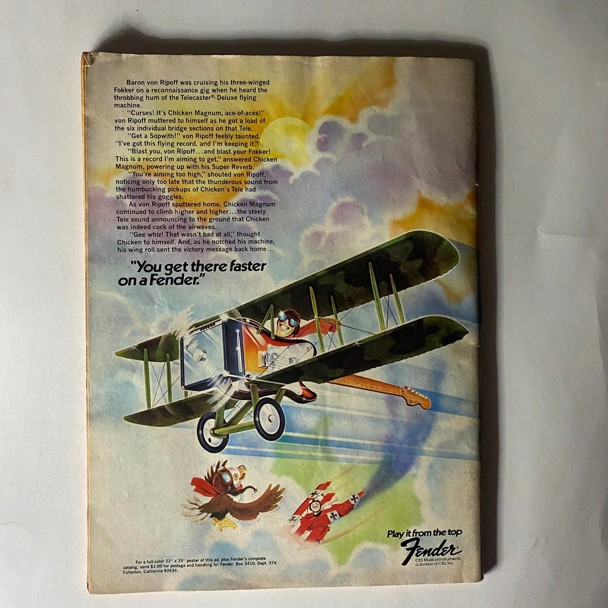 Back cover of VTG Crawdaddy Magazine September 1974 displaying a colorful advertisement for Fender guitars with a whimsical illustration of a pilot in a biplane, reflecting the playful spirit of the time.