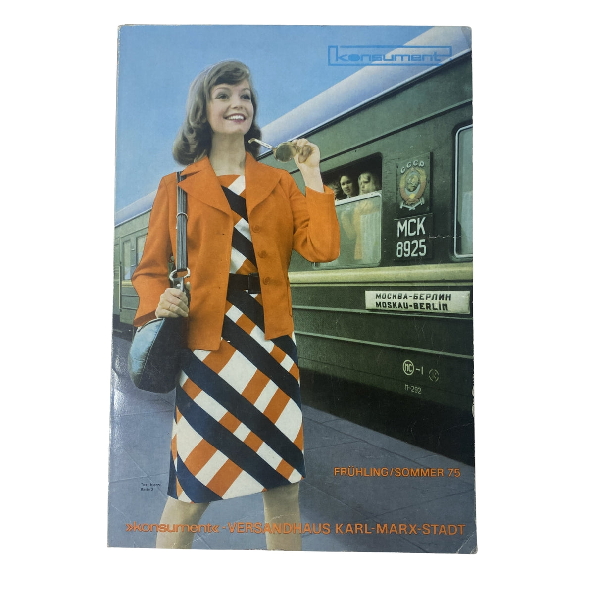 Cover of the 1975 Konsument Summer Catalog featuring a woman in vibrant orange outerwear and geometric patterned dress, showcasing East German fashion.