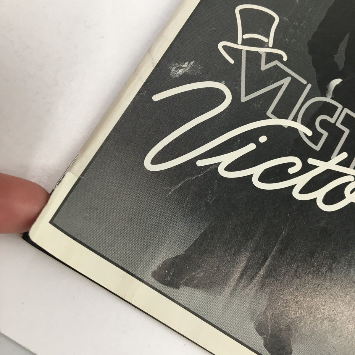 Close-up of the edge of the 1996 Playbill for Victor/Victoria, highlighting minor wear and the protective covering of this collectible item.