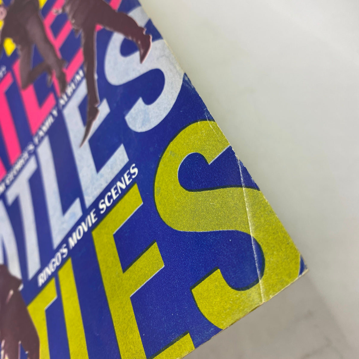 Close-up of the edge of a vintage 1964 The Beatles movie 'A Hard Day's Night' magazine, highlighting wear and tear.