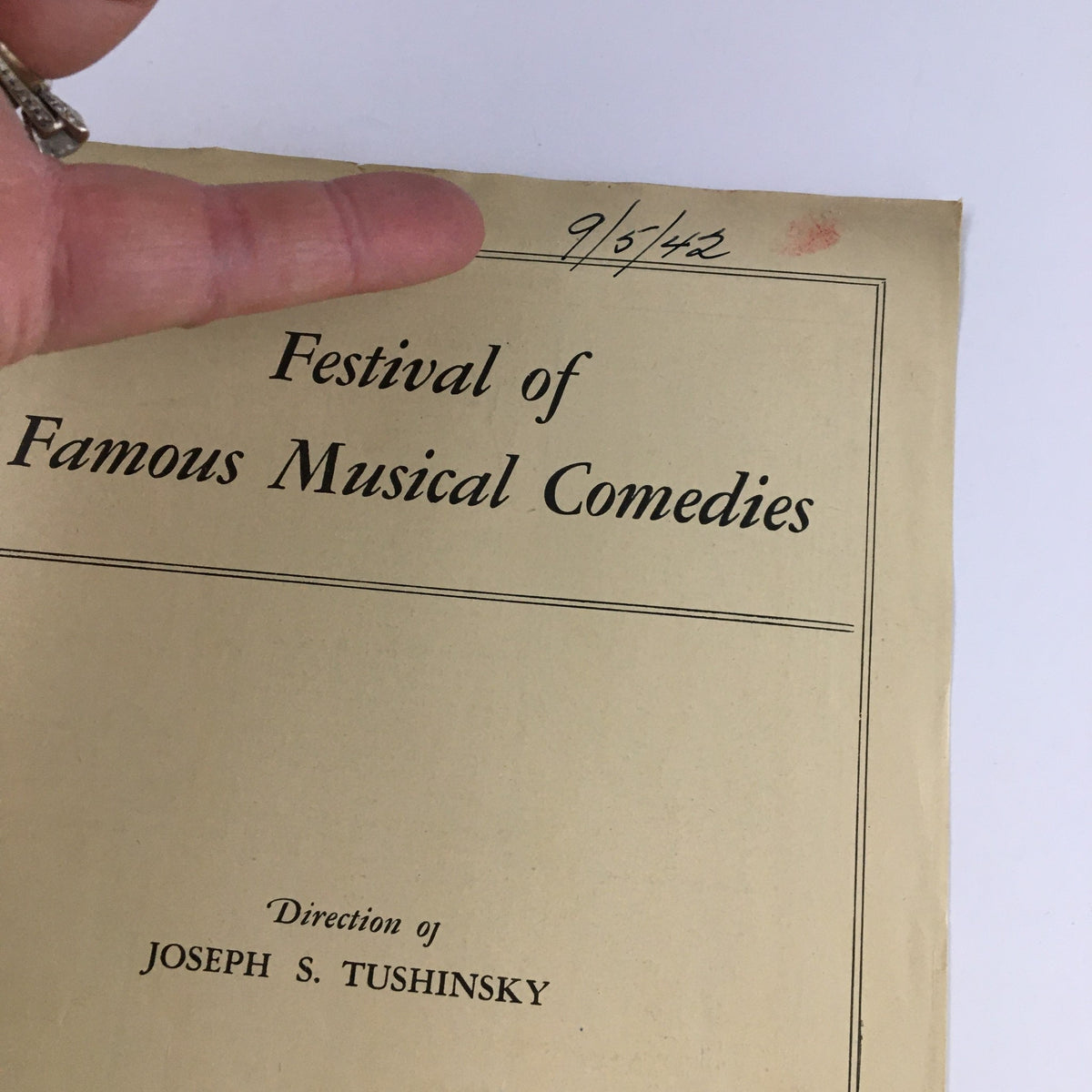Close-up of the cover of the 1942 Festival of Famous Musical Comedies, highlighting the title and direction by Joseph Tushinsky, with a date mark on the top.