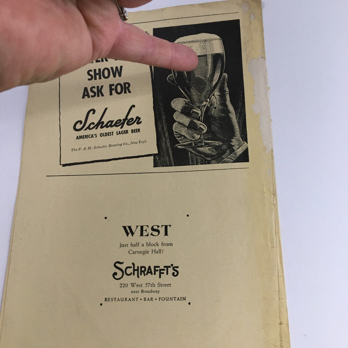 Promotional material for the 1942 Festival of Famous Musical Comedies, displaying a hand holding a glass with a background advertisement for Schaefer beer and restaurant, near Carnegie Hall.