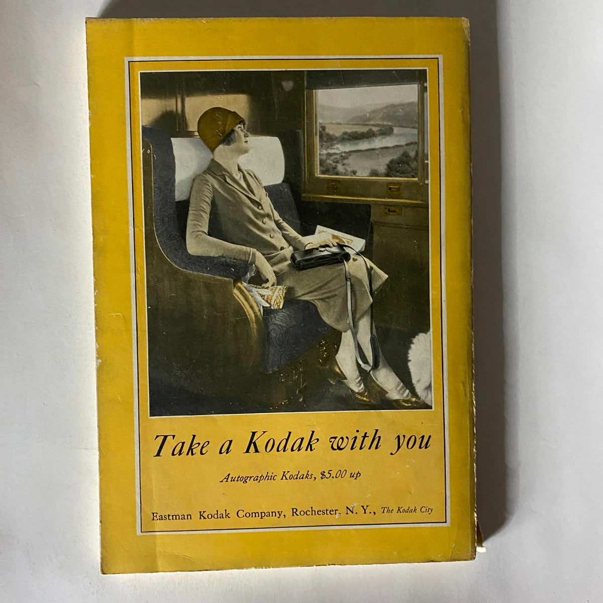 VTG National Geographic Magazine July 1926 featuring a vintage advertisement for Eastman Kodak Company illustrating a woman in a stylish outfit sitting and taking photographs, highlighting the theme of exploration and photography.