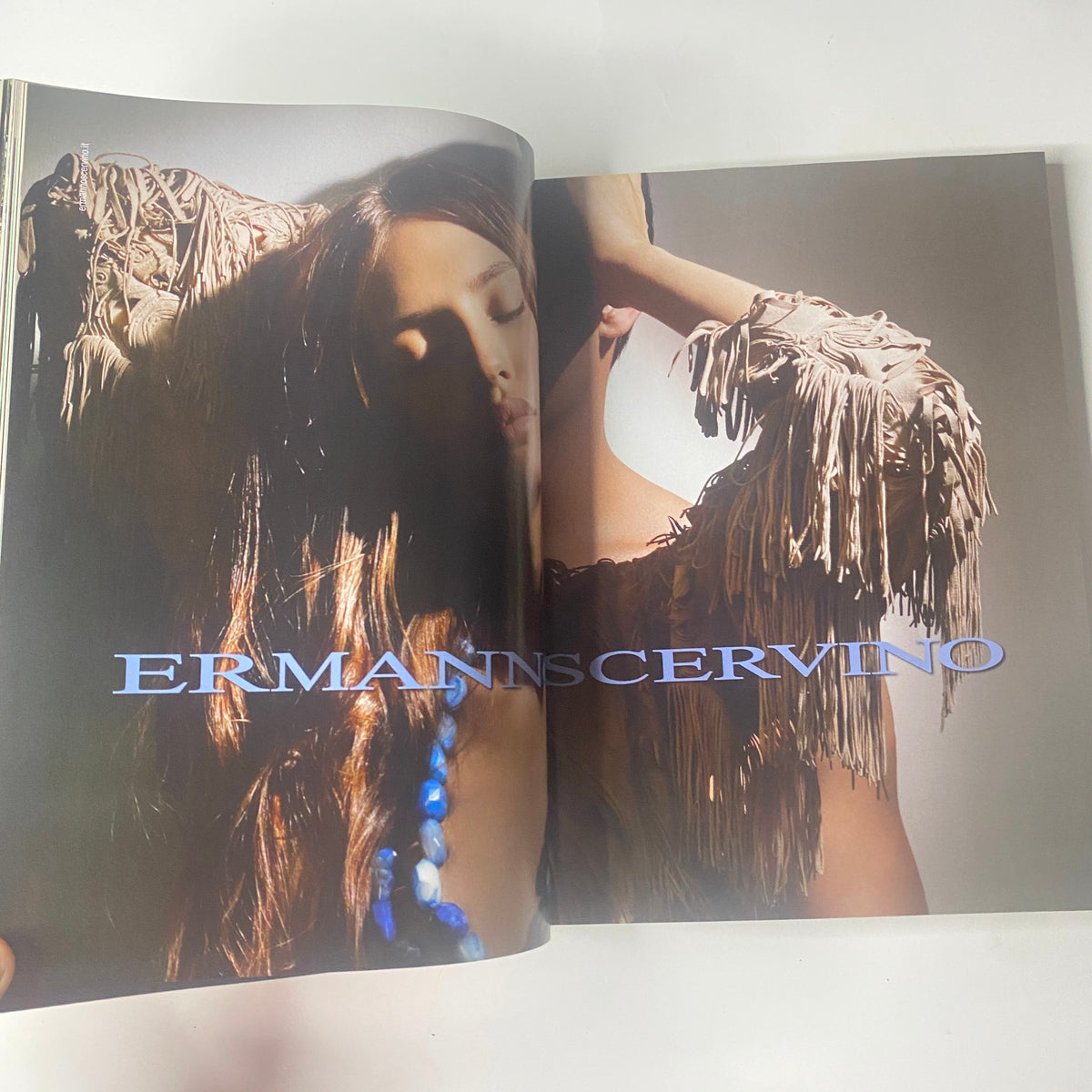 Interior page from the 2009 First Love Spring and Summer Catalog showcasing a modeling shot with a focus on fashion by Ermanno Scervino, highlighting a serene expression and detailed clothing.