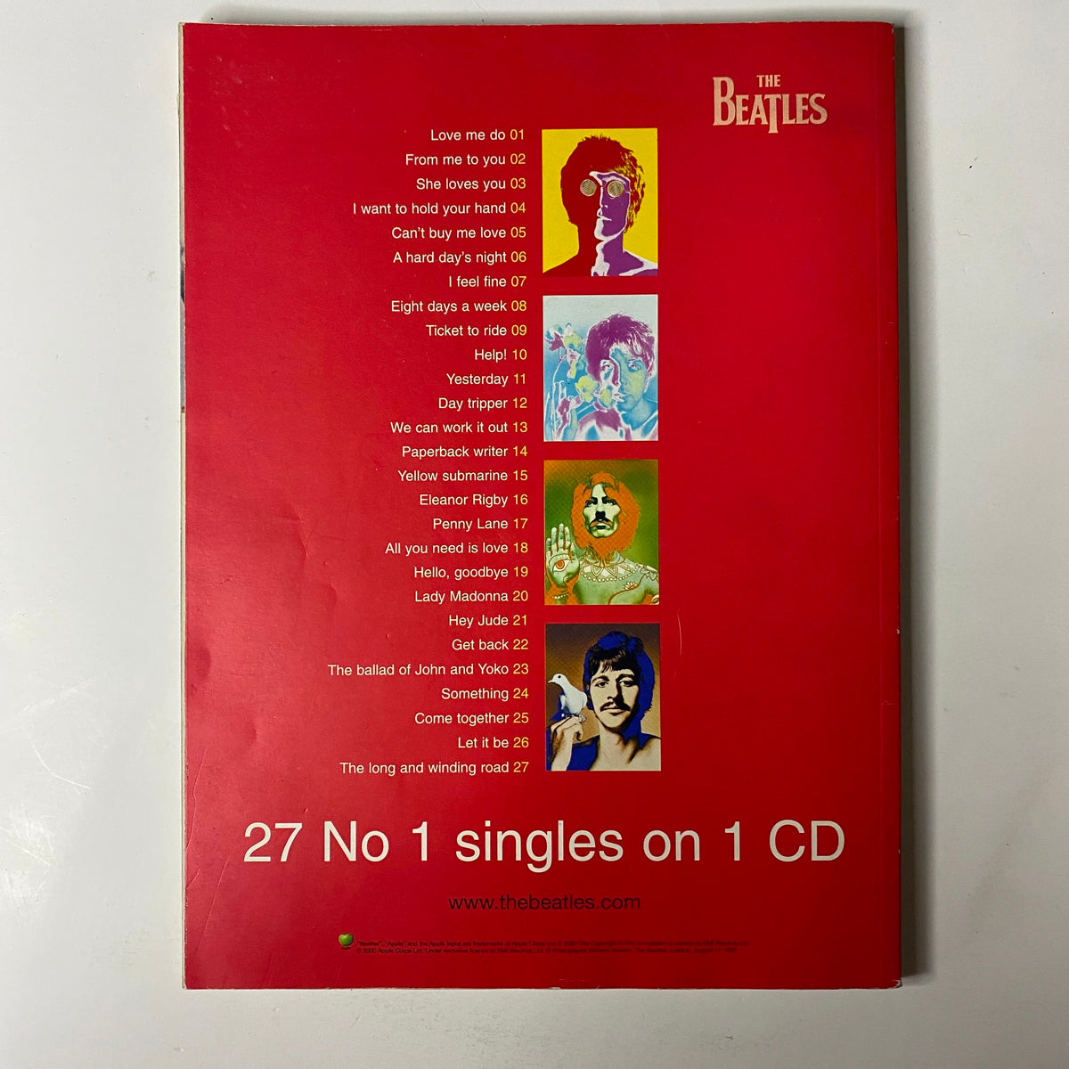 Back cover of Mojo Music Magazine December 2000 featuring AC/DC, showcasing a collection of Beatles song titles and their corresponding track numbers. The design emphasizes vintage music themes, making it a collector's item for fans of classic rock.