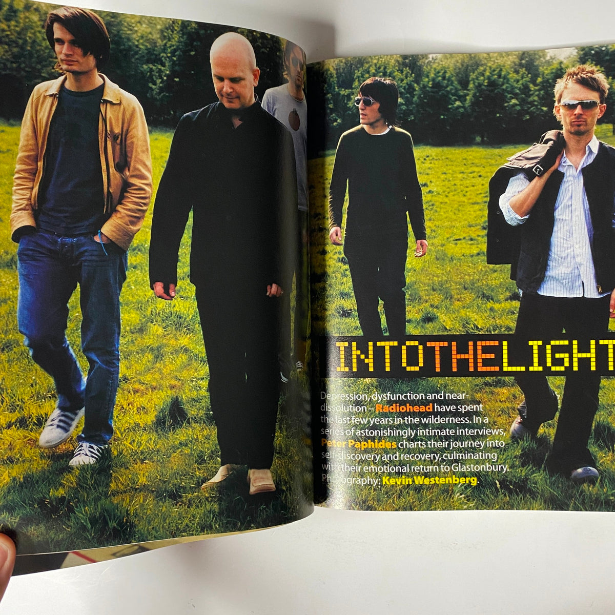 Radiohead featured in Mojo Music Magazine August 2003, walking outdoors, illustrating the band's connection to nature during their interview.
