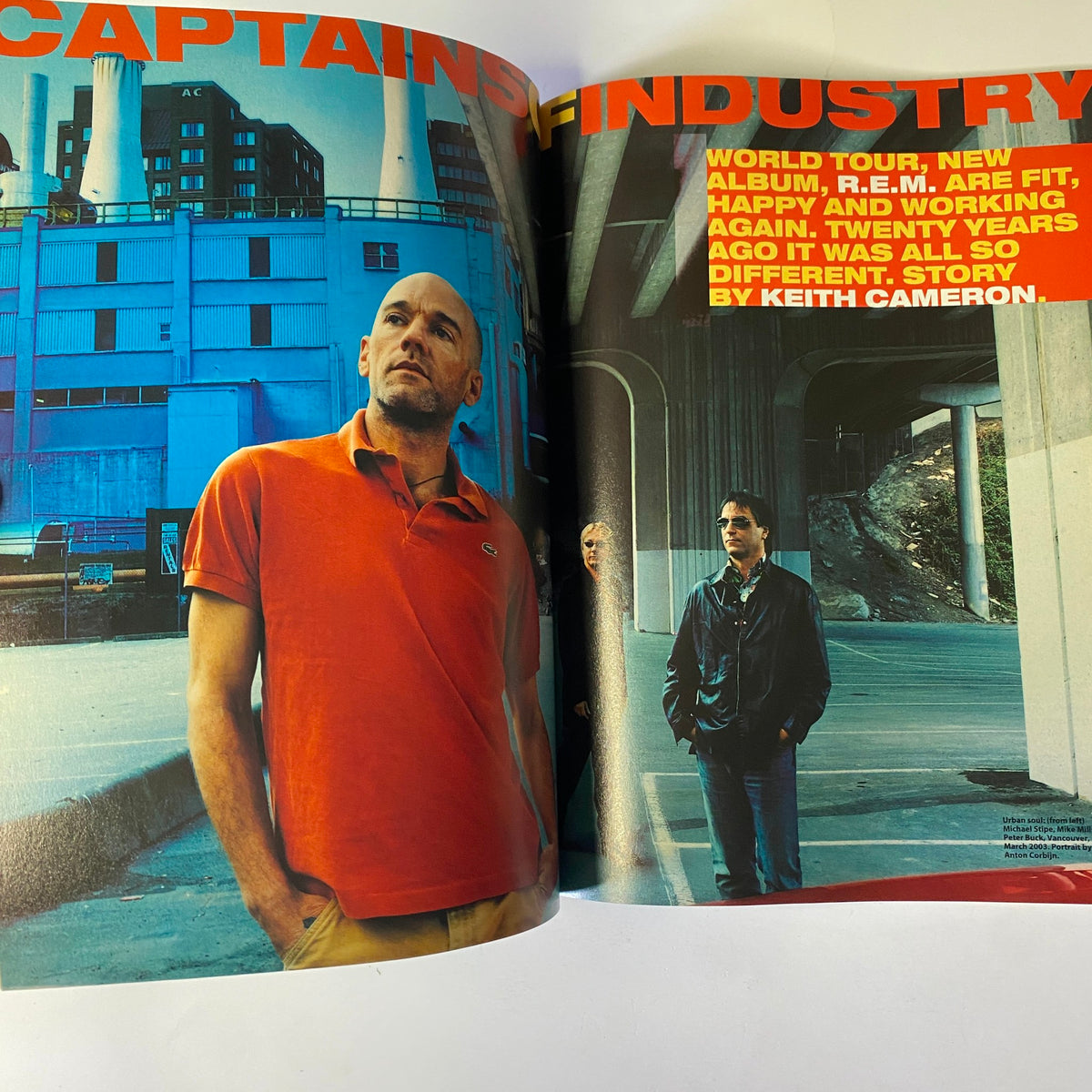 A spread from Mojo Music Magazine July 2003 titled 'Captain's Industry,' discussing R.E.M.'s new album and their world tour, featuring insights from band members and a striking visual backdrop.