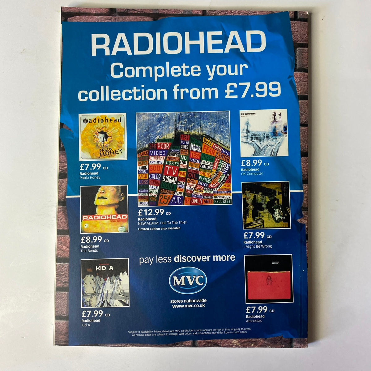 Back cover of Mojo Music Magazine from July 2003 featuring promotional advertisements for Radiohead albums and merchandise. The cover displays colorful album covers with prices and a call to action to 'Complete your collection from £7.99'. This magazine issue highlights R.E.M. on the cover, emphasizing its significance in music history.