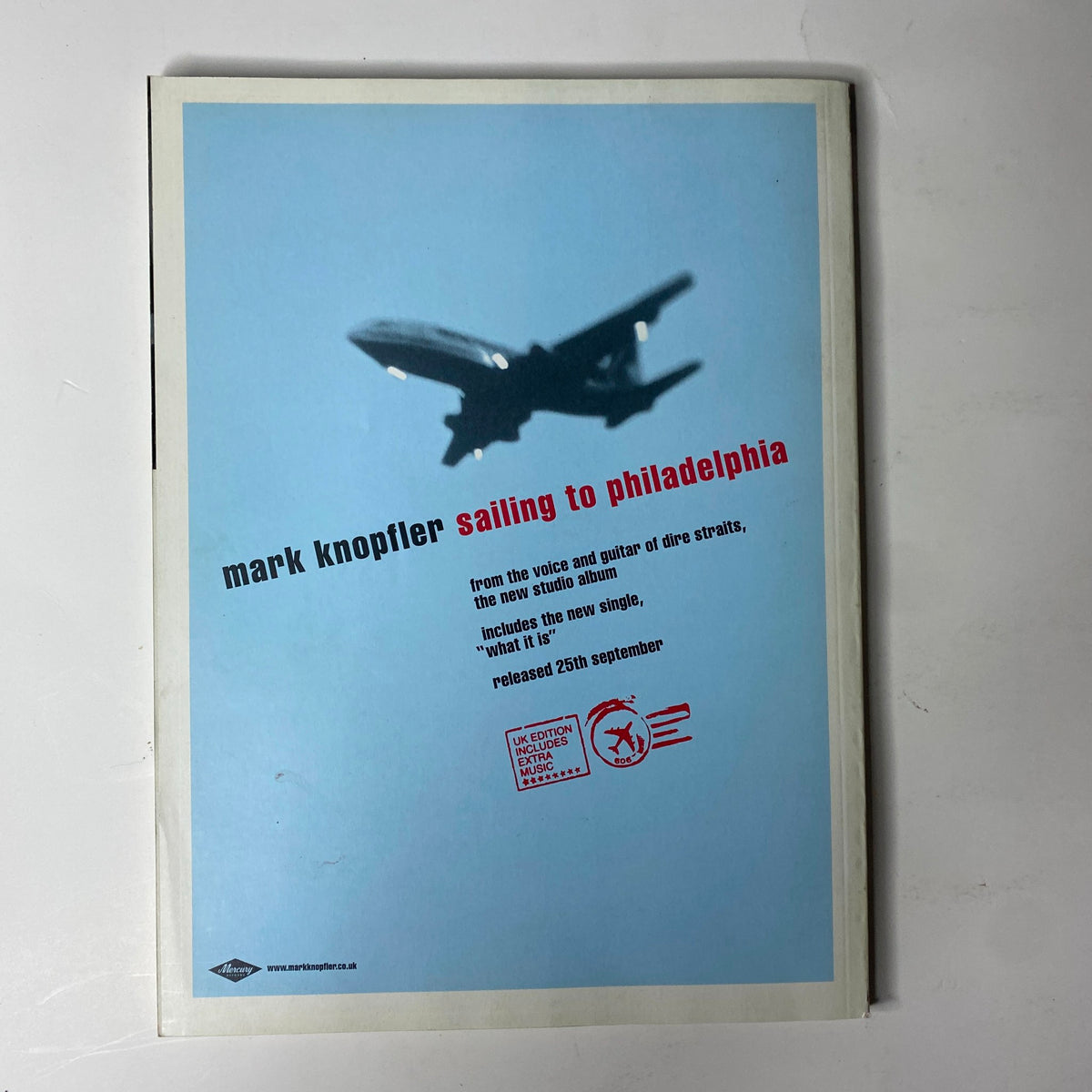 Promotional advertisement for Mark Knopfler's 'Sailing to Philadelphia,' featuring an airplane silhouette, related to the October 2000 issue of Mojo Music Magazine with The Beatles cover. This advertisement highlights Knopfler's album and includes the release date.