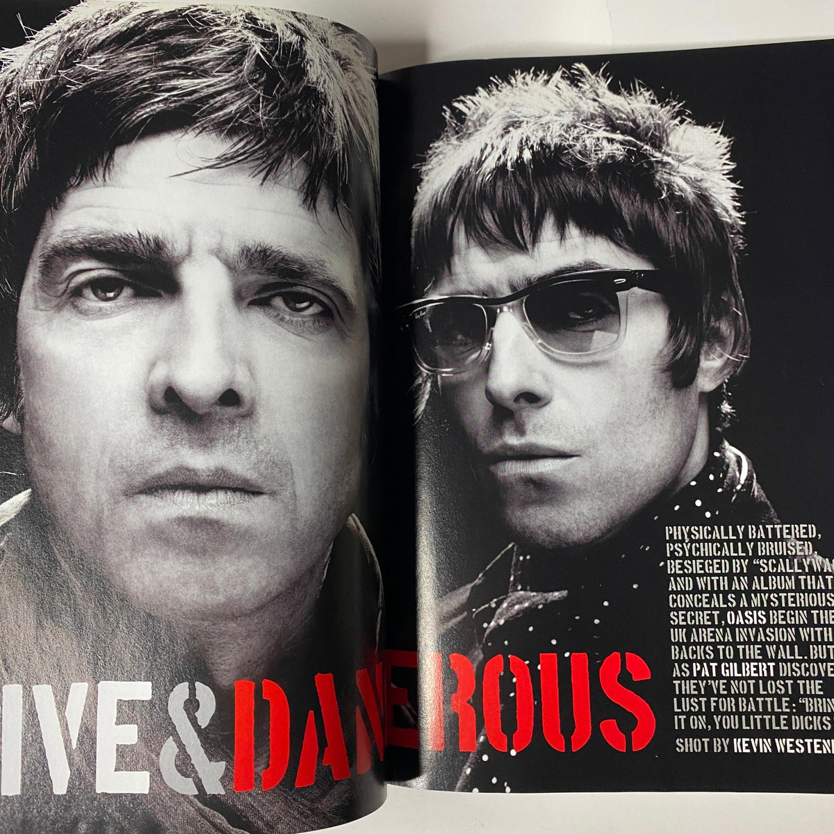 Double page spread in Mojo Music Magazine January 2009 displaying close-up portraits of Noel and Liam Gallagher from Oasis, emphasizing their striking features.