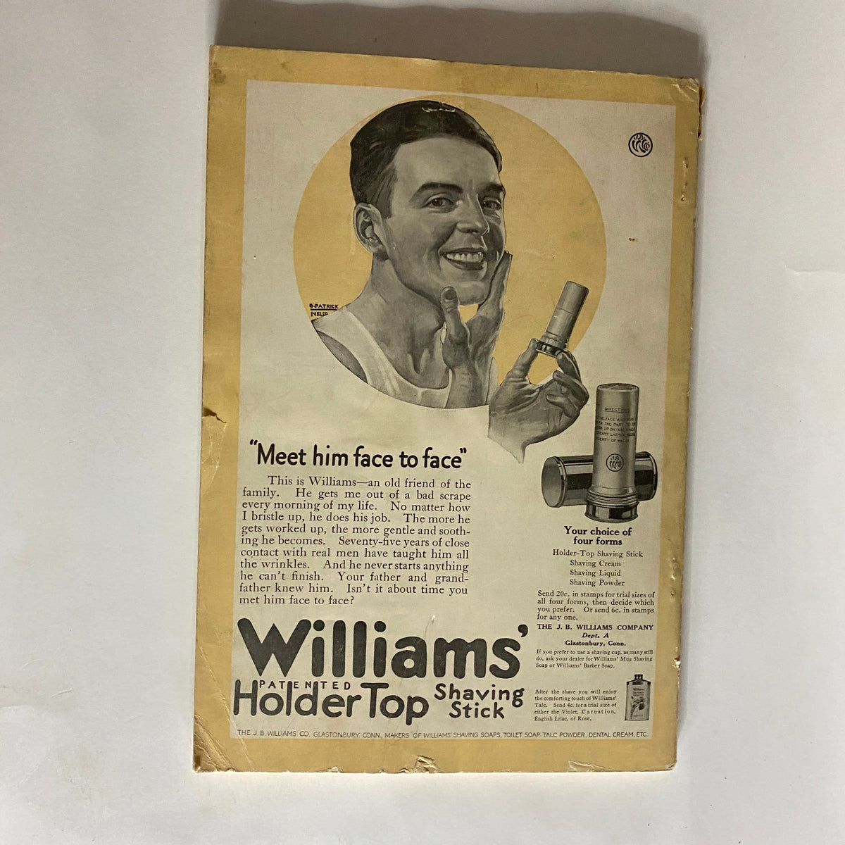Vintage advertisement from the January 1920 VTG National Geographic Magazine featuring Williams' Holder Top Shaving Stick. The ad showcases a friendly man smiling while holding the shaving stick, with a background element and promotional text. The advertisement highlights details about the product, emphasizing its effectiveness and heritage, making it a unique collectible feature of this magazine issue.