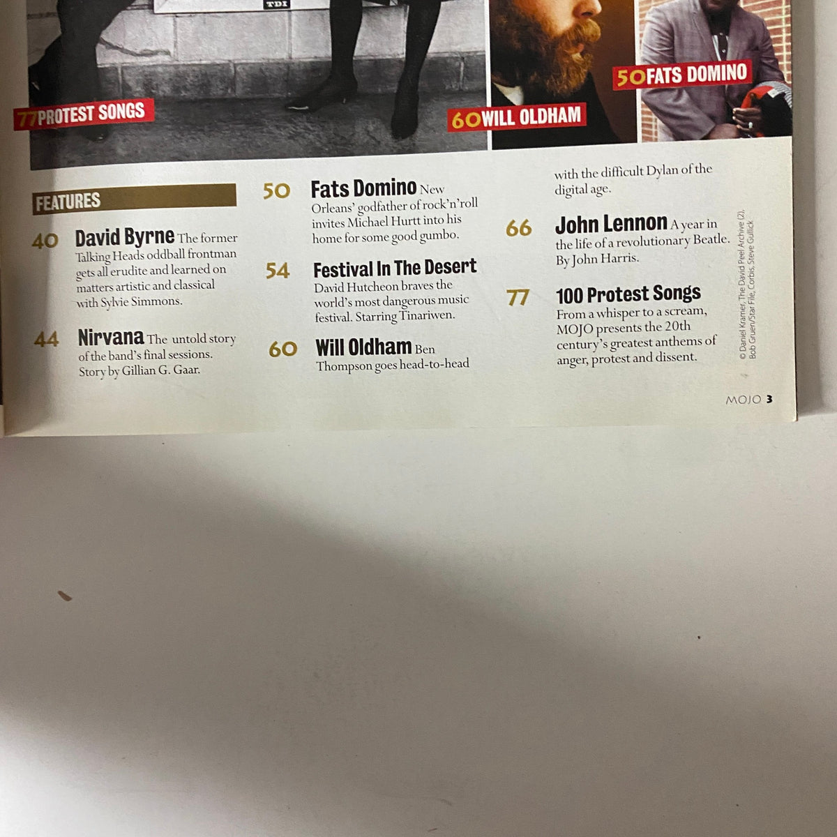 Contents page from Mojo Music Magazine May 2004 listing articles on Fats Domino, Will Oldham, John Lennon, and protest songs.