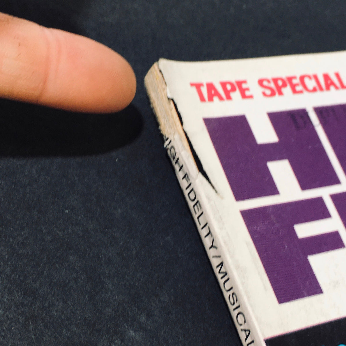 Close-up of the spine of the Vintage High Fidelity Magazine February 1977, revealing wear and tear indicative of its age.