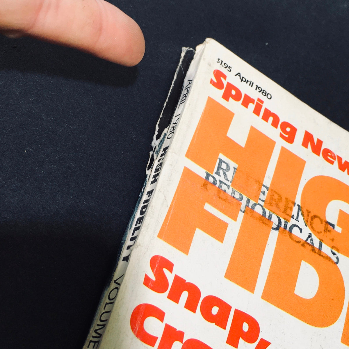 Close-up view of the spine of High Fidelity Magazine from April 1980, featuring visible wear and tear, showcasing its title 'High Fidelity' prominently printed with vintage style, illustrating the magazine's collector's value.