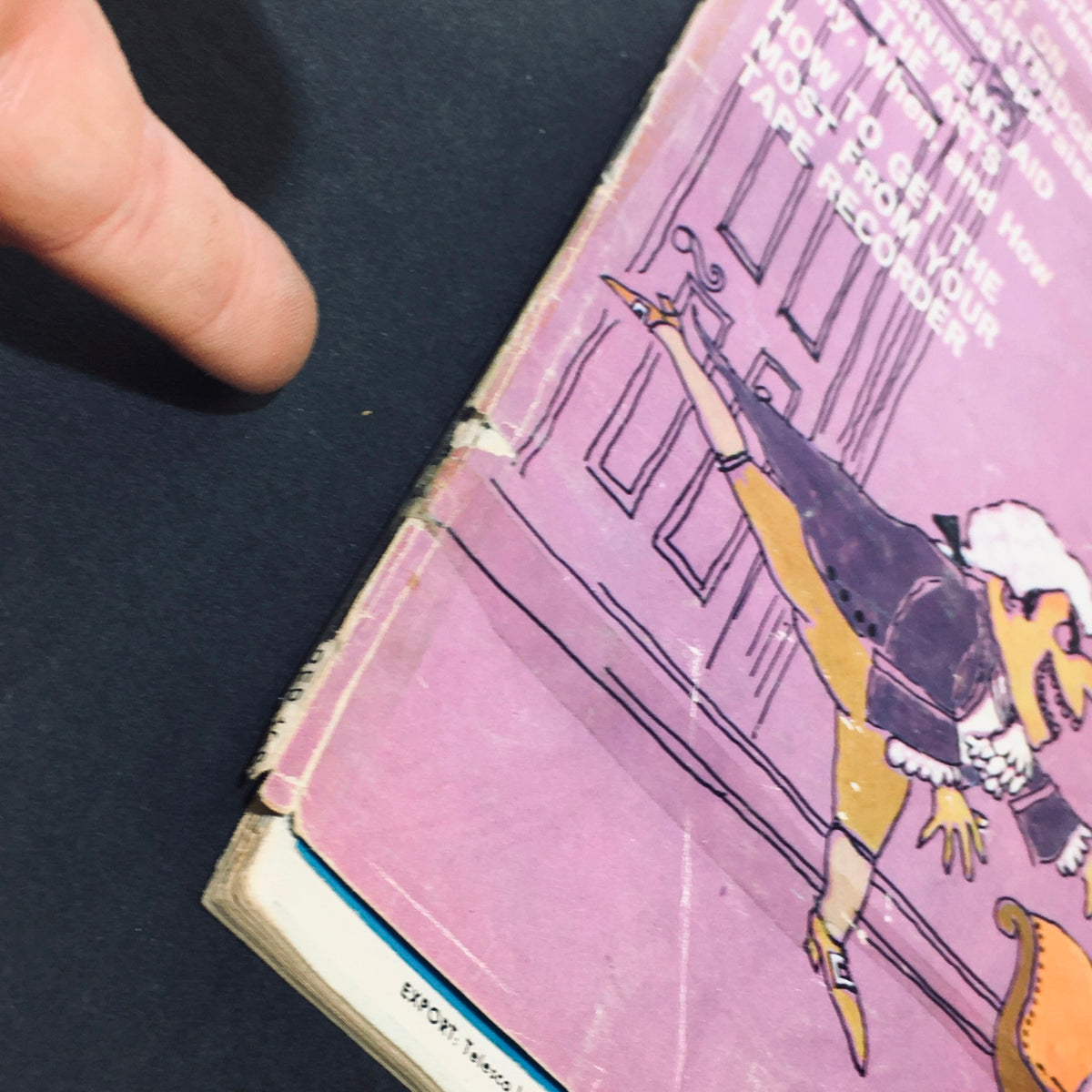 Close-up of the binding area of the VTG HiFi Stereo Review Magazine from November 1961. The image captures a finger pointing towards the worn edge, illustrating the vintage condition and taped binding of the magazine.