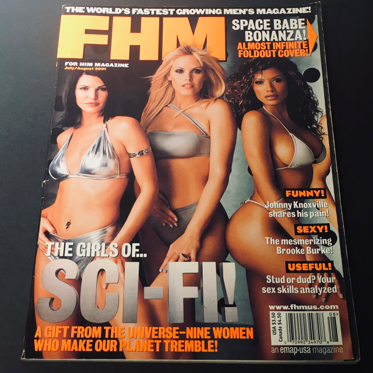 FHM Magazine July August 2001 cover featuring Traci Bingham, Gena Lee Nolin, and Brooke Burke in metallic swimwear, emphasizing pop culture from the early 2000s.
