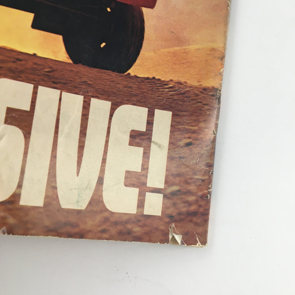 Detail of the "AGGRESSIVE!" text from the 1985 Toyota 4x4 SR5 magazine advertisement, showcasing off-road capabilities, as featured in the Sports Illustrated Magazine December 10 1984 featuring Michael Jordan.
