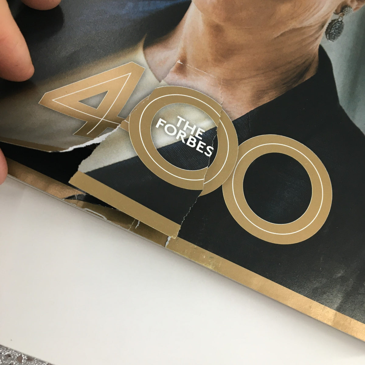 Examination of the Forbes Magazine cover from October 7, 2013, depicting Warren Buffett, with a focus on the damaged portion near the Forbes 400 title.