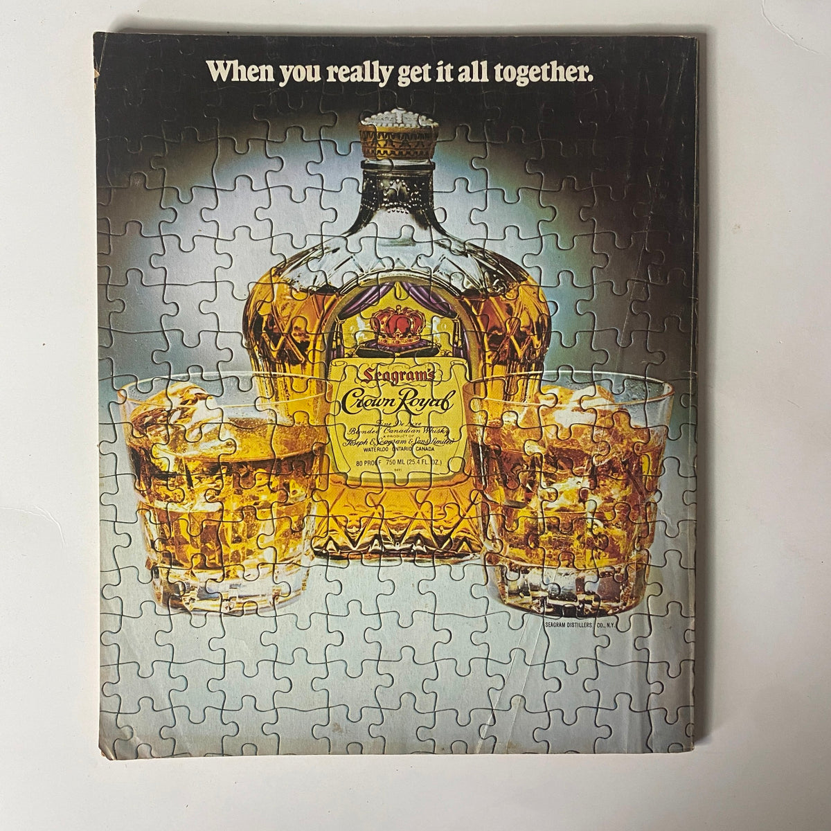 Puzzle cover of a vintage advertisement featuring an elegant whiskey bottle and glasses, complementing the insightful content of Fortune Magazine July 2, 1979.
