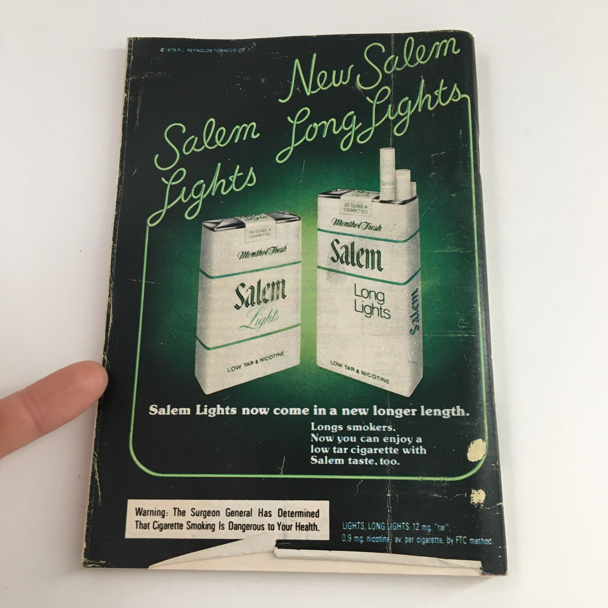 Back cover of TV Guide Magazine December 4, 1976 featuring an advertisement for Salem Lights cigarettes, emphasizing the product's new longer length and including a health warning.