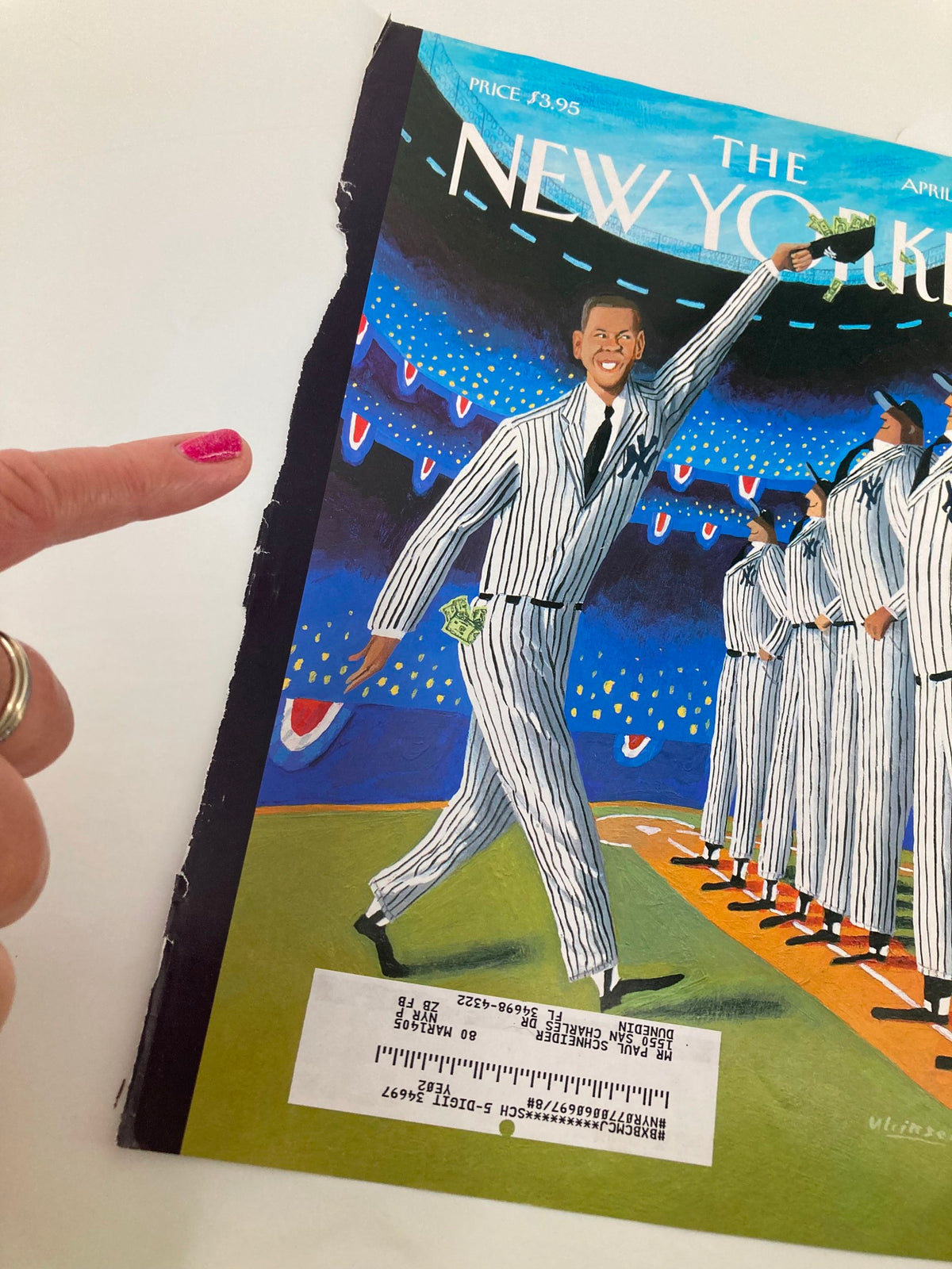 Close-up of The New Yorker April 5 2004 Cover - Stars & Stripes Forever by Mark Ulriksen with a hand pointing at the art, emphasizing the detailed illustration of a celebratory figure in a baseball context.