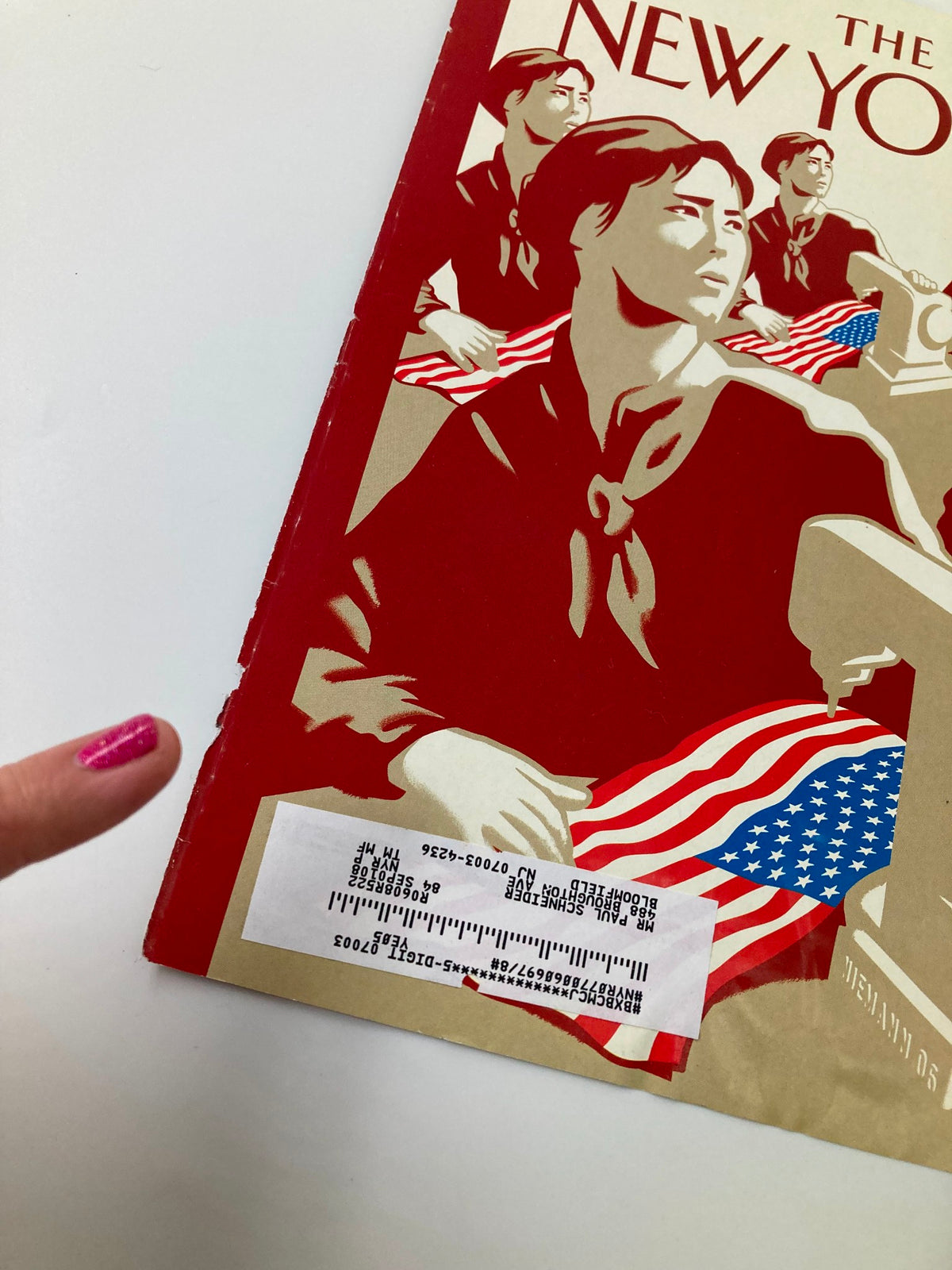 Detailed view of The New Yorker July 3 2006 cover 'Dependence Day' by Christoph Niemann, highlighting figures and sewing machines with a visible price sticker.