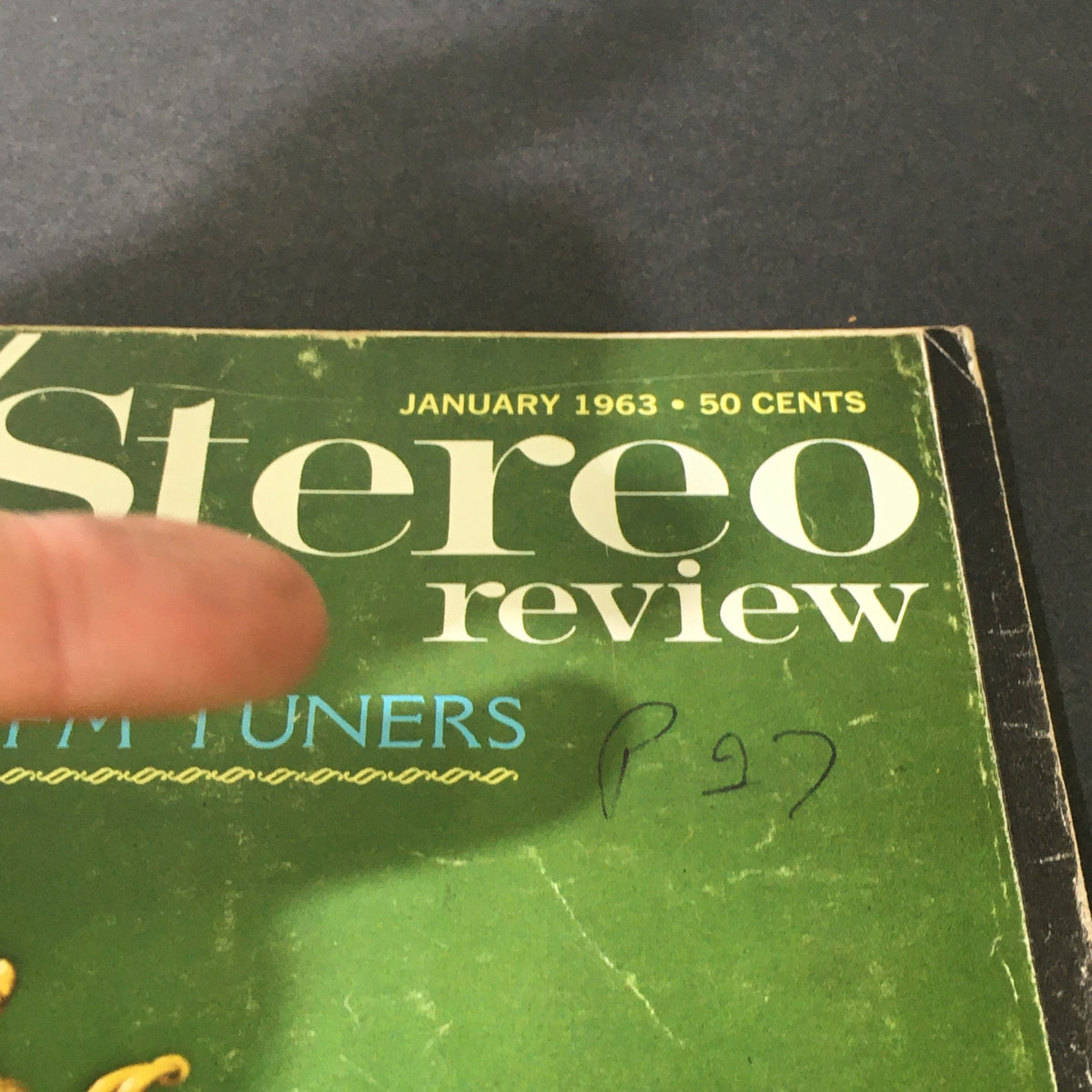 Close-up detail of the HiFi Stereo Review Magazine January 1963 cover, highlighting the title and the mention of stereo FM tuners, adorned with decorative streamers and gold sculptures.