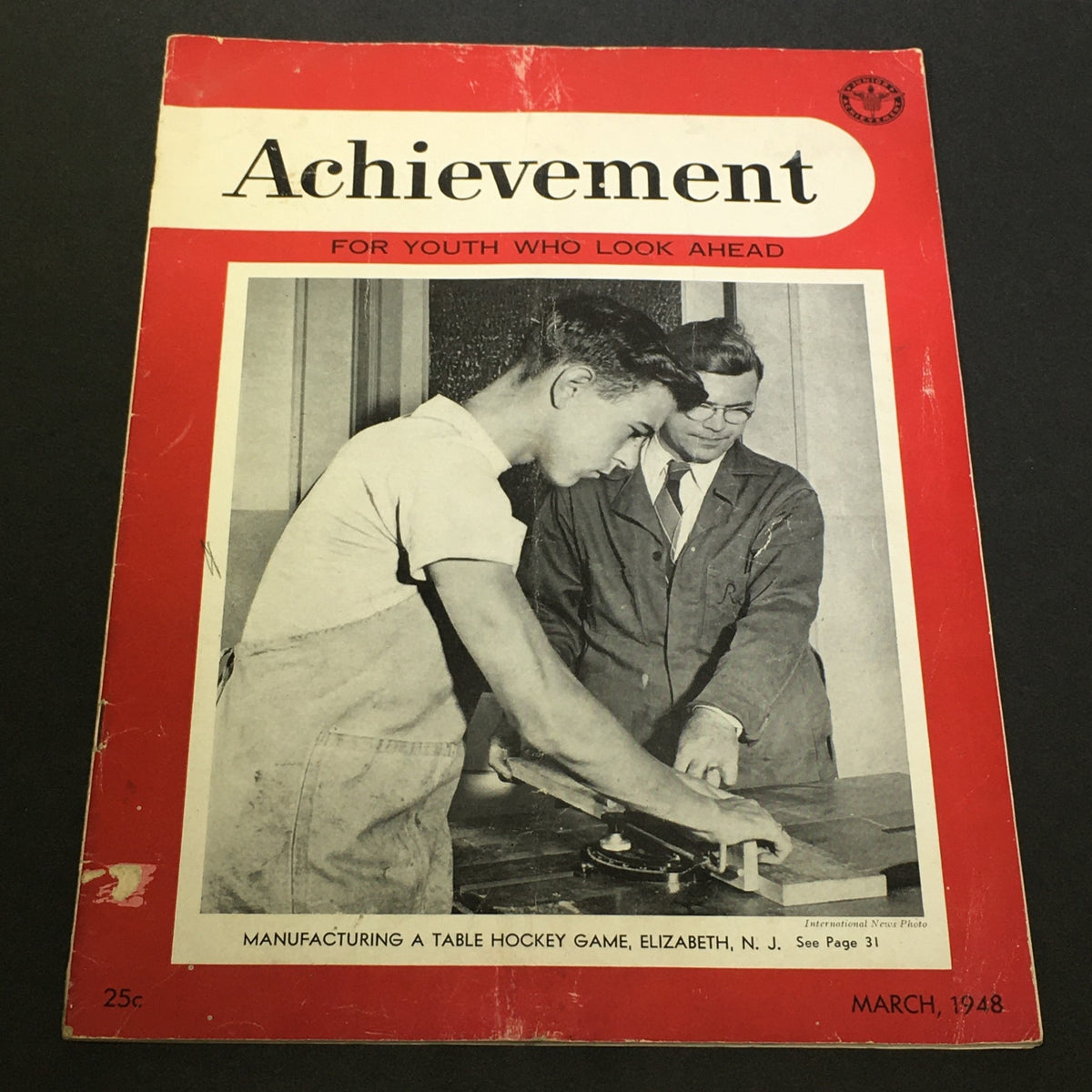Cover of VTG Achievement Magazine March 1948 featuring a young man and an instructor working on a table hockey game, highlighting the educational theme 'FOR YOUTH WHO LOOK AHEAD.'
