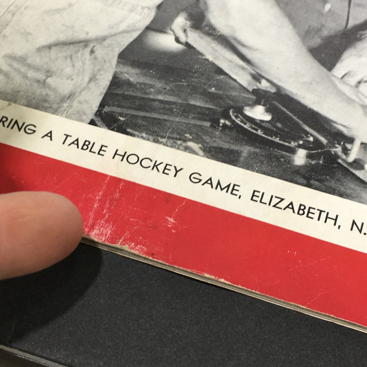 Detailed close-up of the lower section of the VTG Achievement Magazine March 1948 cover showing wear and the manufacturing theme, 'MANUFACTURING A TABLE HOCKEY GAME, ELIZABETH, N.J.'