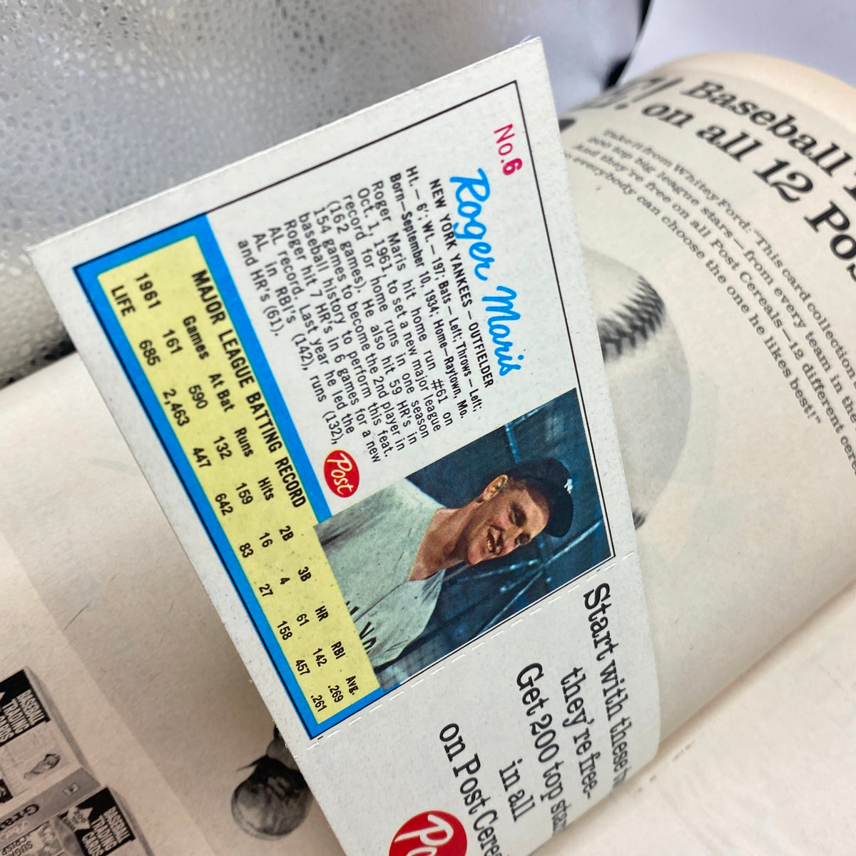 Roger Maris baseball card from Post Cereals, showcasing player statistics and a vibrant image, featured in the April 13, 1962 issue of Life Magazine with Elizabeth Taylor.