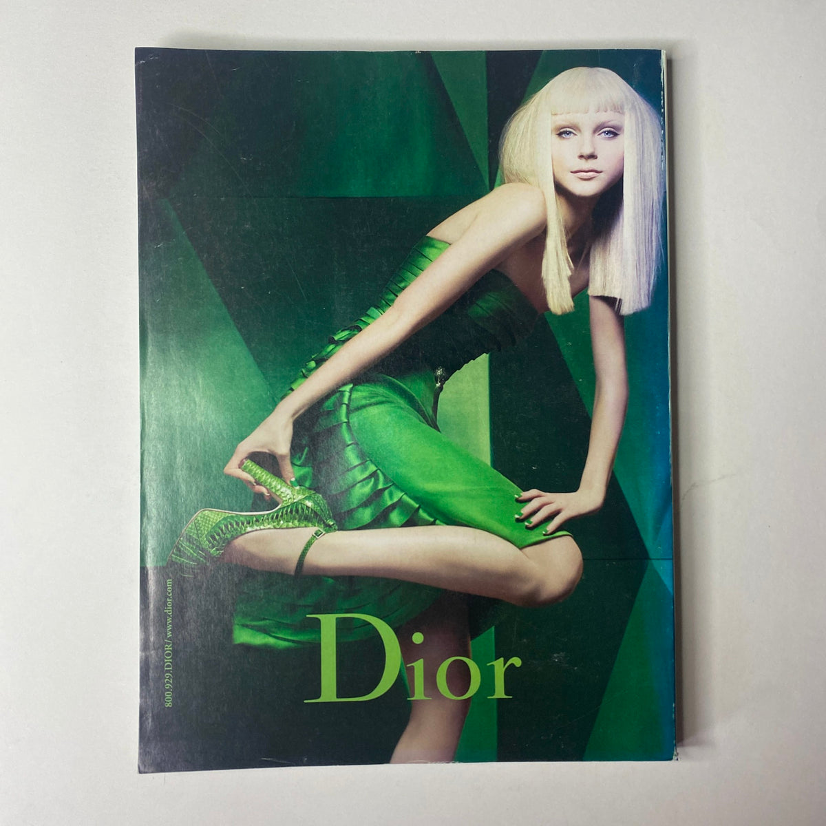 Dior advertisement displaying a model in a vibrant green dress, striking a pose, from Vogue Magazine August 2007 with Winona Ryder on the cover.