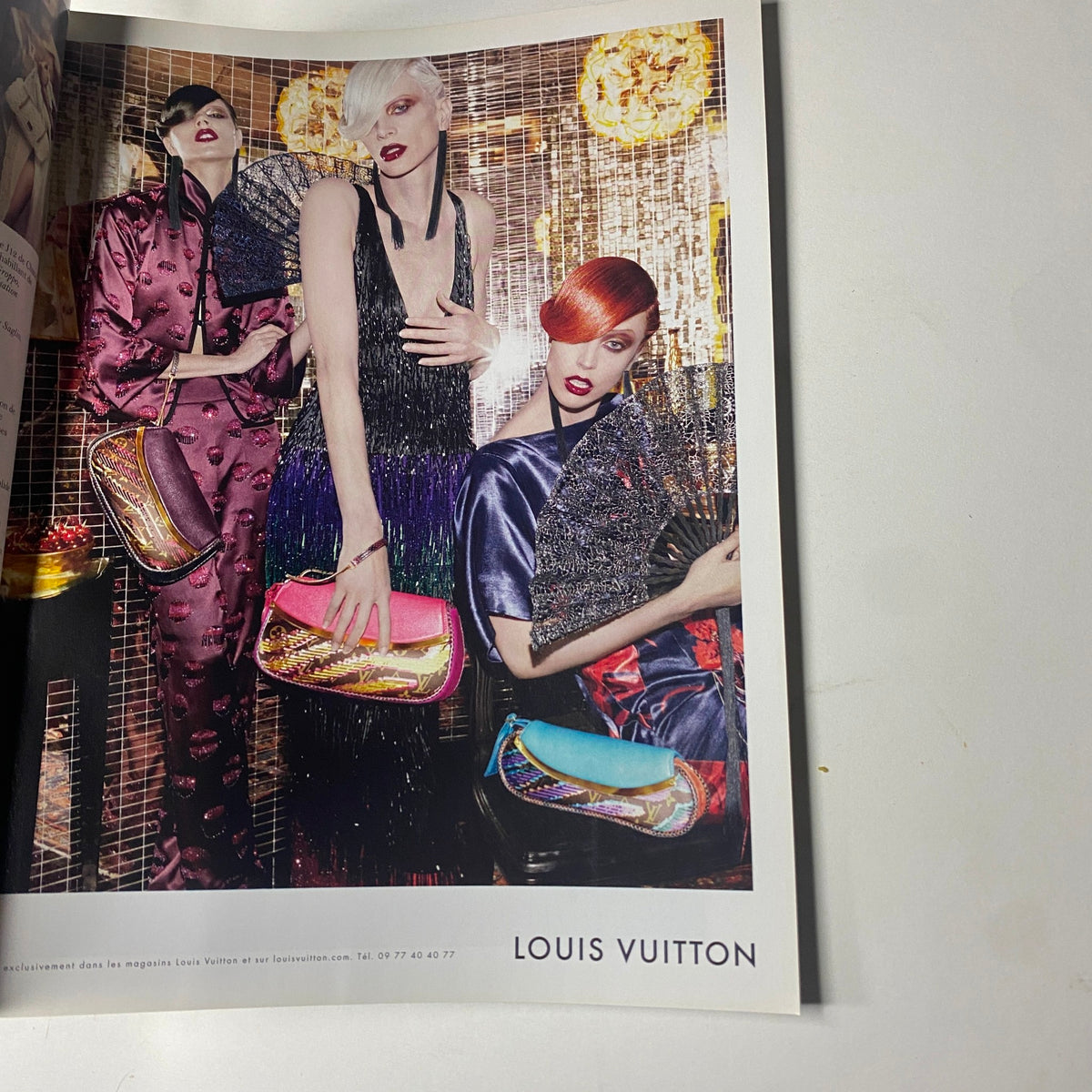 Louis Vuitton advertisement featuring three models in glamorous outfits, showcasing handbags, from the Vogue Paris Magazine April 2011 No. 916 Gisele Bündchen Cover.