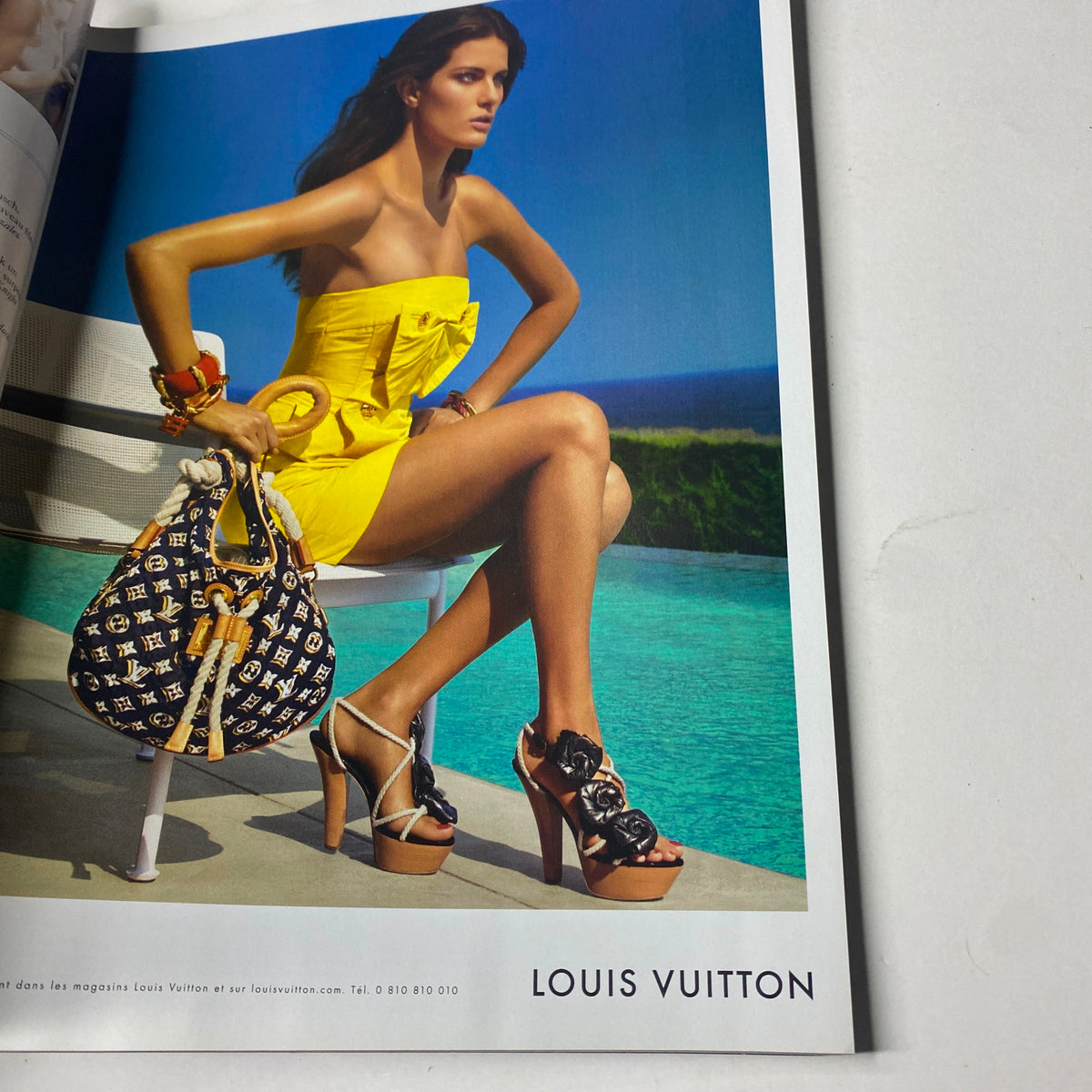 A vibrant Louis Vuitton advertisement featured in Vogue Paris Magazine December 2009, showcasing a model in a striking yellow dress paired with a designer handbag.