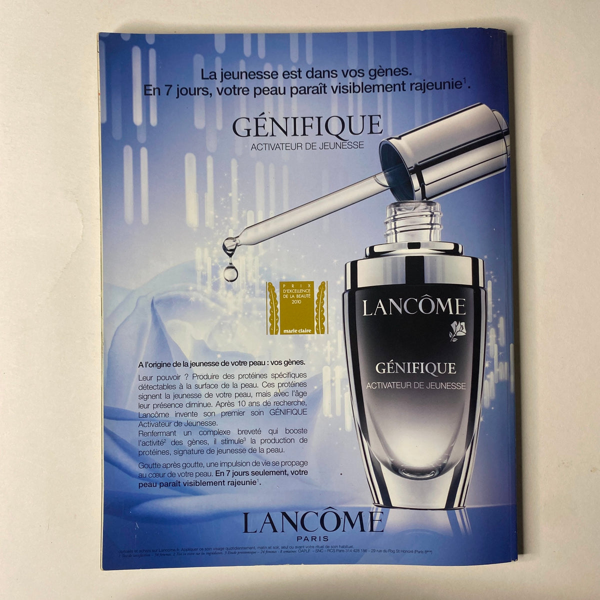 Advertisement for Lancôme Génifique, featured in Vogue Paris Magazine June - July 2010 No. 908. The ad highlights the youth activating serum with a sleek design and promises visible rejuvenation in seven days.