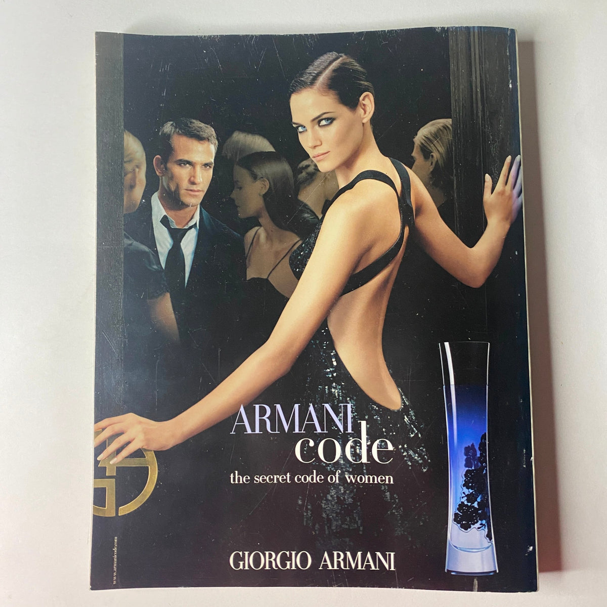 Giorgio Armani advertisement for Armani Code, featuring a striking model in a backless gown, embodying elegance and allure, from Vogue British Magazine November 2006.