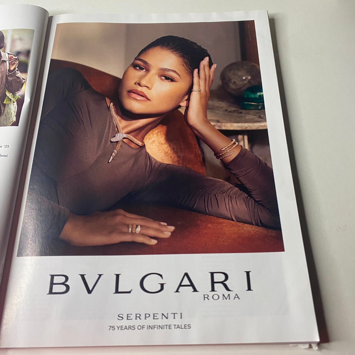 Advert for Bvlgari featuring a model elegantly posed, showcasing Serpenti jewelry, on the inside of Vogue British Magazine August 2023.