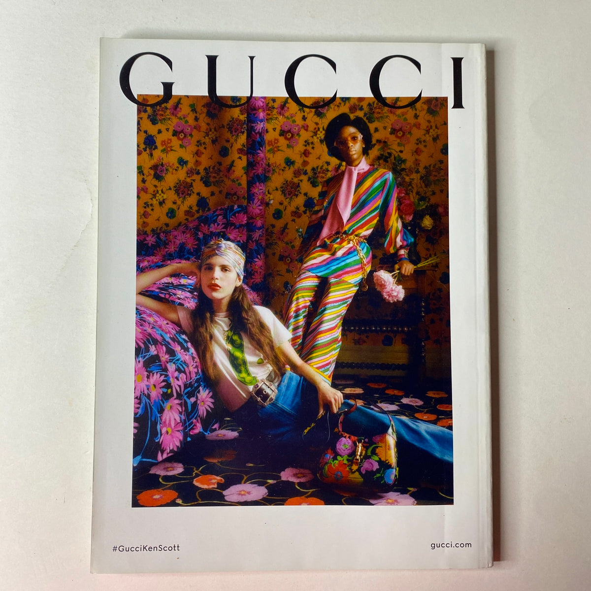 Striking Gucci advertisement in Harper's Bazaar May 2021, featuring models in vibrant designs against a floral-patterned backdrop, highlighting bold fashion statement.