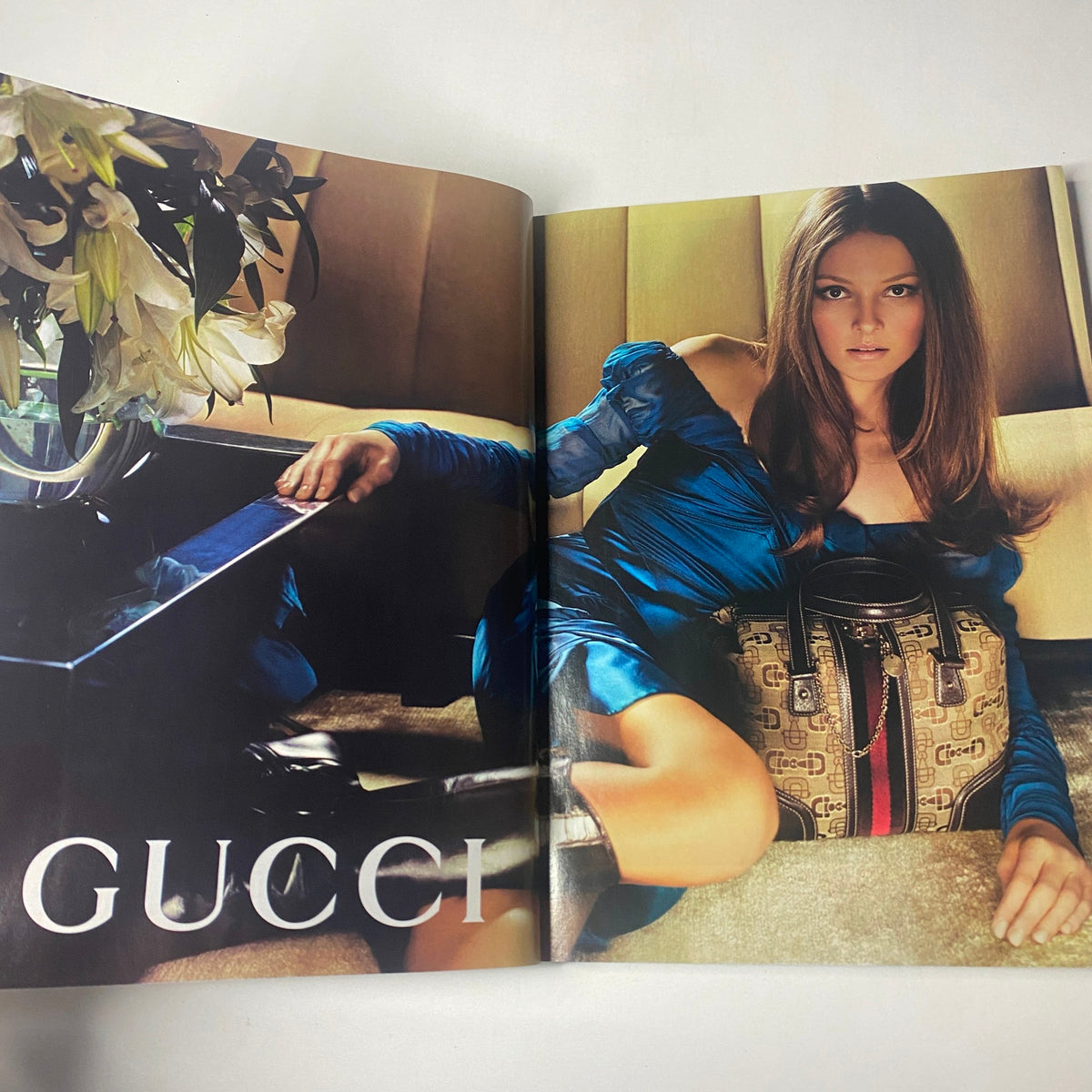 Gucci fashion spread from Harper's Bazaar Magazine October 2005, displaying a stylish model with a luxurious handbag and floral arrangement.