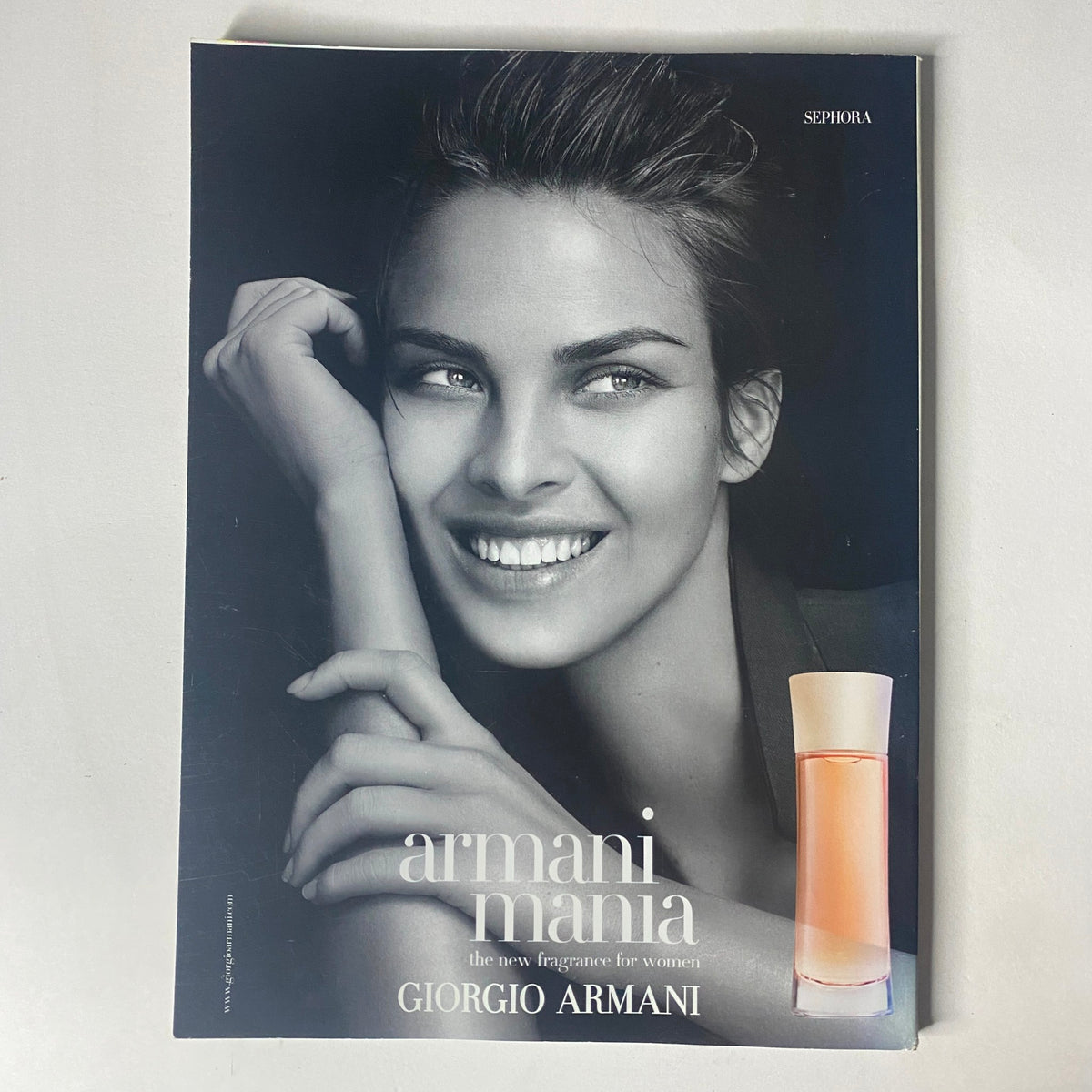 Giorgio Armani Mania advertisement featuring a model with flawless skin, promoting the women's fragrance, from the Harper's Bazaar Magazine November 2004.