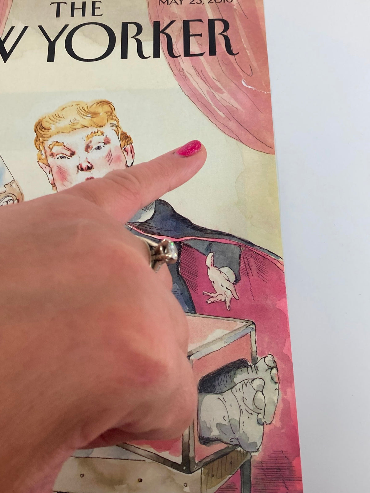 Detailed view of The New Yorker May 23 2016 cover with Donald Trump illustrated by Barry Blitt, highlighting playful elements like an elephant and human feet, with a hand pointing at the cover.