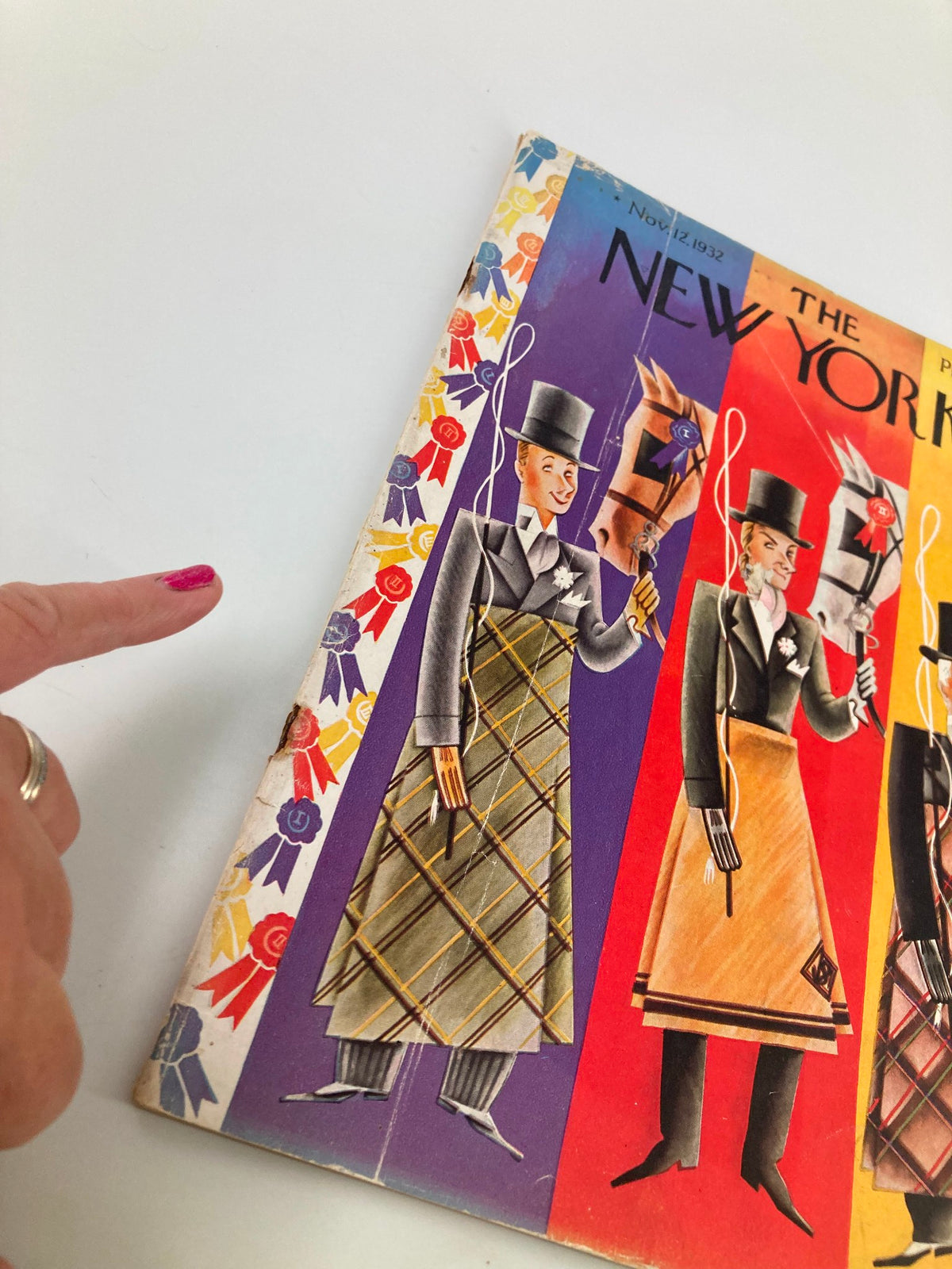 Close-up view of The New Yorker Magazine cover from November 12, 1932, highlighting intricate details of the 'Horsemen' illustration by Constantin Ajalov, with a woman's hand pointing at the cover.