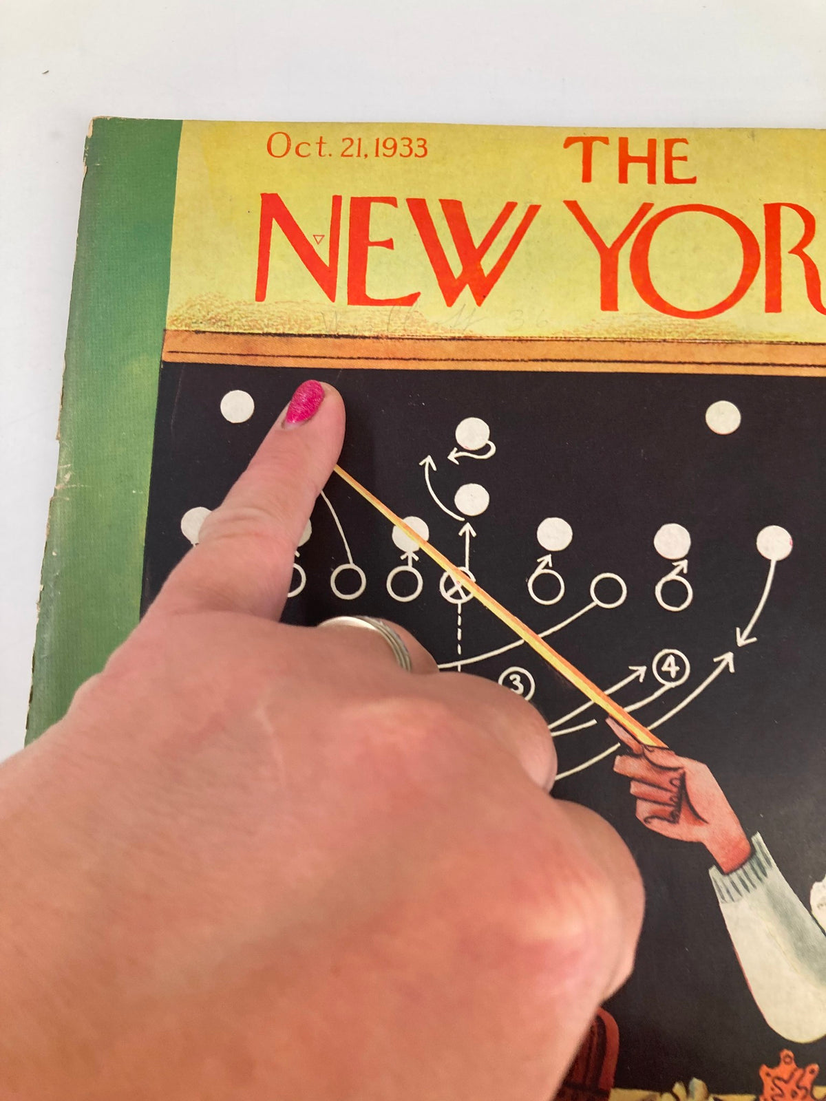 Another close-up of The New Yorker Magazine October 21, 1933 cover, highlighting a hand pointing at the football strategy diagram created by Harry Brown.