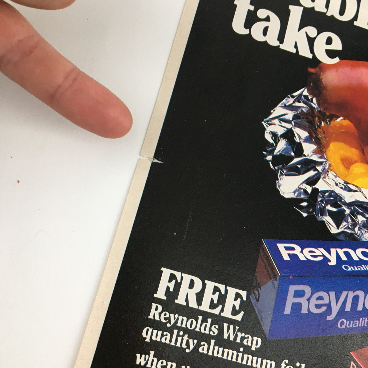 1983 Reynolds Wrap Aluminum Foil Circular Coupon Advertisement featuring a hand pointing at the advertisement, showcasing the product and promotional details.