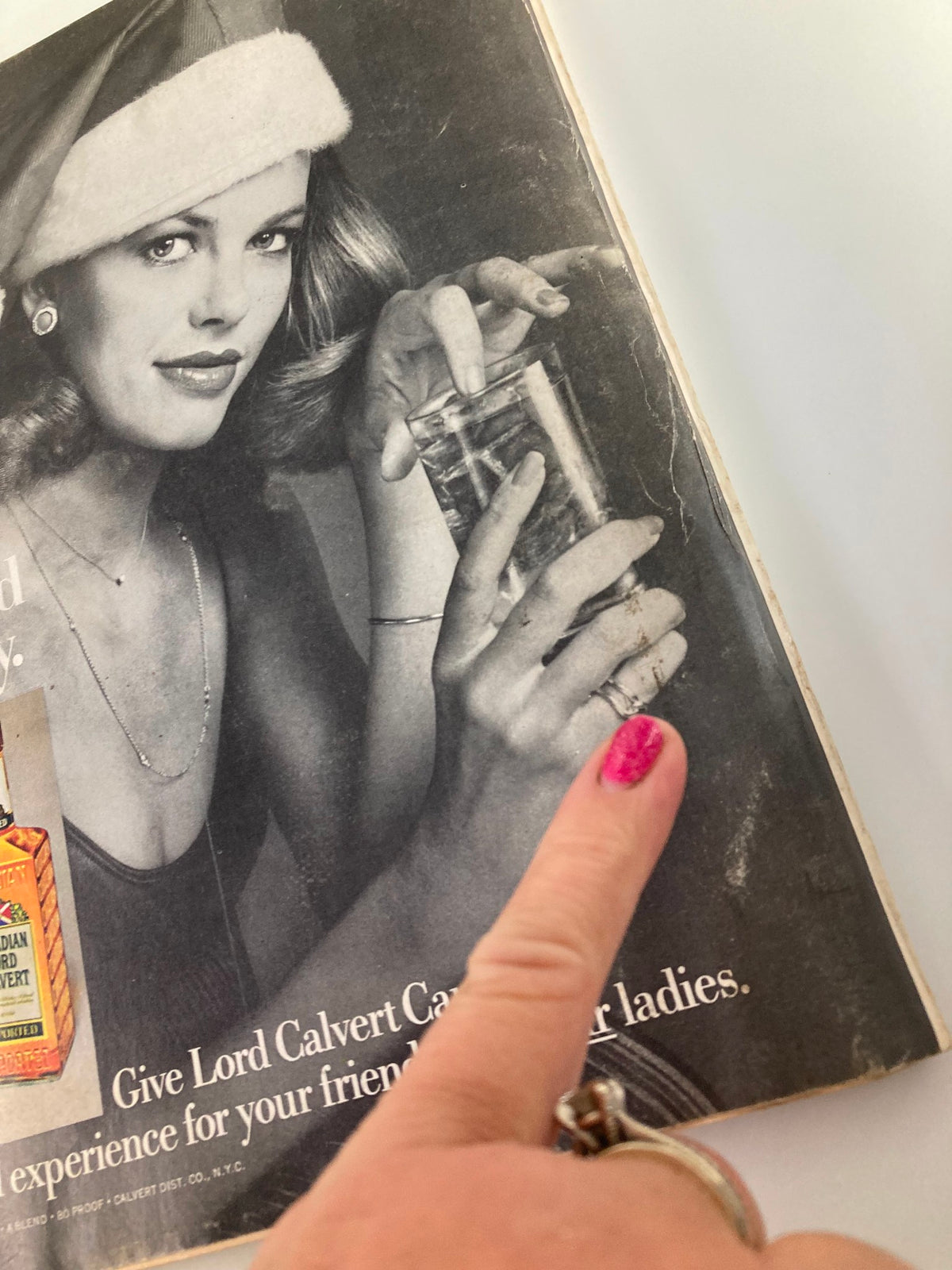 Image from VTG Esquire Magazine December 1975 featuring a woman in a Santa hat holding a drink, highlighting vintage holiday glamour and advertising aesthetics.