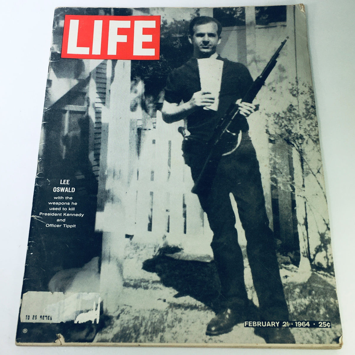 Vintage Life Magazine cover from February 21, 1964, featuring Lee Oswald holding a weapon linked to the assassination of President Kennedy, showcasing a pivotal moment in American history.