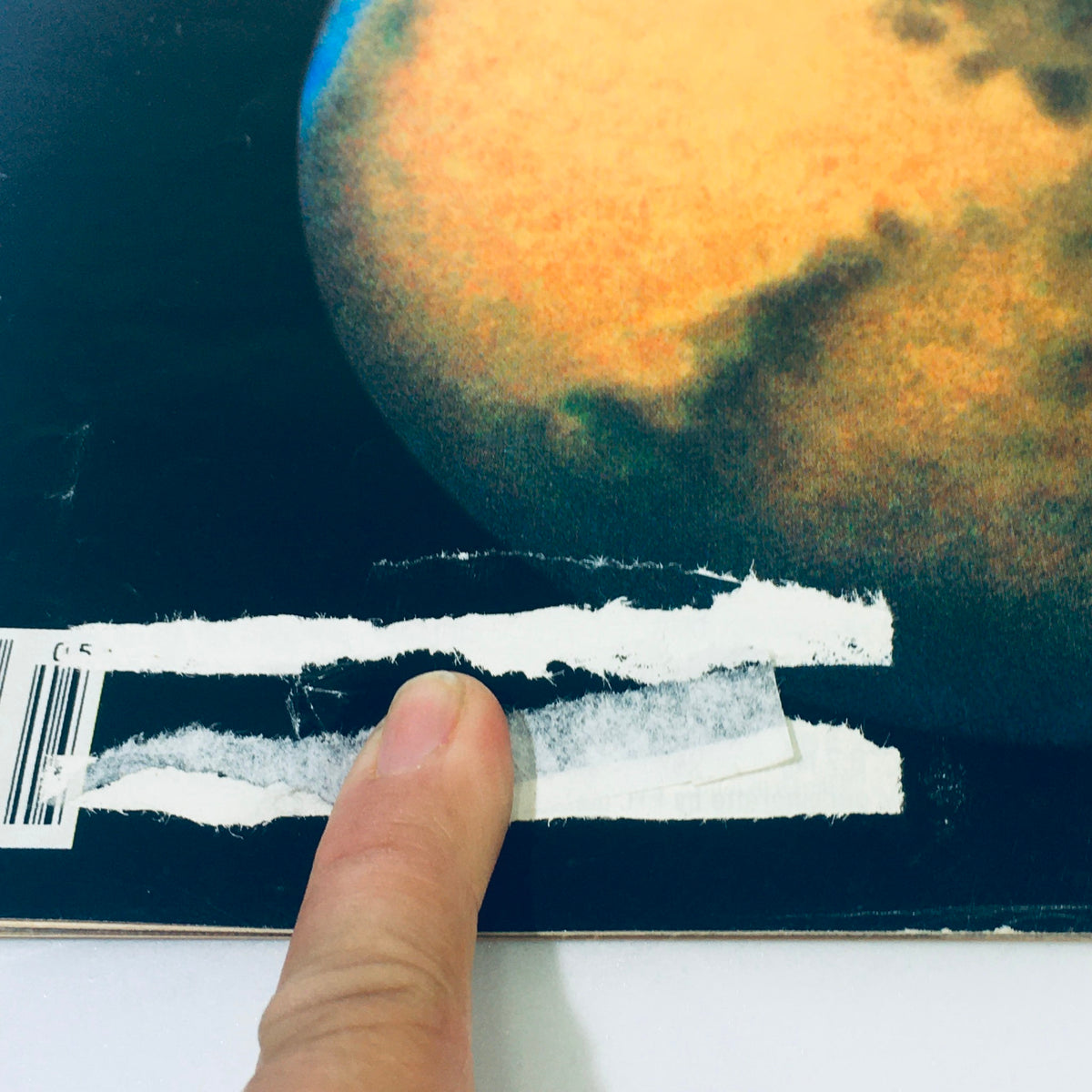 Close-up of the back cover of the VTG Life Magazine May 1991 - Mars Our Next Home / Liberate the Military, showing a finger pointing at a visible barcode and a damaged area revealing wear on the magazine.