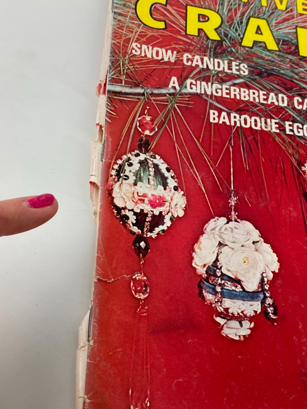 Close-up view of VTG Creative Crafts Magazine December 1974 cover highlighting decorative ceramic bells and floral designs alongside a person's finger pointing to the craft details.